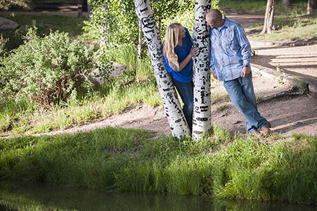 Engaged couple standing by aspens in Fox Run Park, Black Forest, Colorado.