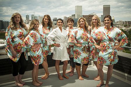 Bride and bride's maids in robes, posing on rooftop in Denver