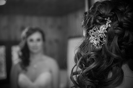 Bridal hair brooch with bride looking in mirror