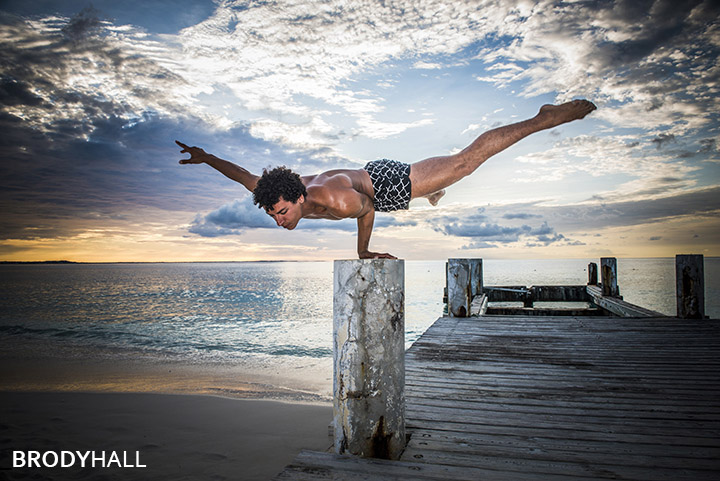Male acrobat performing on a pier at Club med in the Turks & Caicos islands