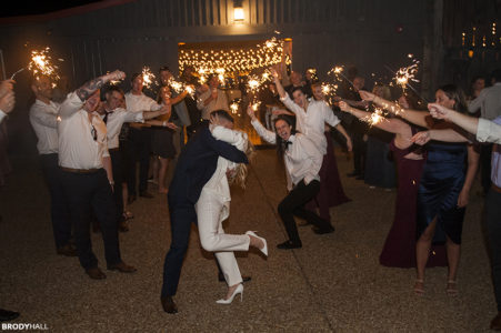 A Nashville Bride and groom stopping for a kiss at their grand exit sparkler line.