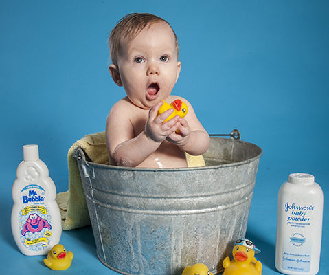baby-taking-bath Baby Zen with a surprised look on his face as he takes a bath in studio, mom giving him a mow hawk.