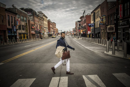 man-walking-downtown-Nashville A man walking across Broadway in downtown Nashville